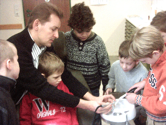 Das Foto zeigt den Schulzahnarzt Dr. Tilman Kramer, wie er Kindern die Behandlung von Zähnen zeigt. 