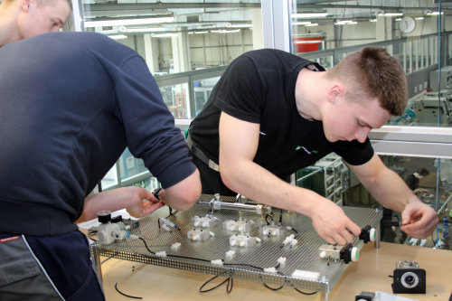 Praktischer Unterricht in der Ausbildungswerkstatt der Montaplast GmbH: Auszubildende des ersten Lehrjahrs zum Werkzeug- und Industriemechaniker montieren anhand von Schaltplänen (Foto: OBK).