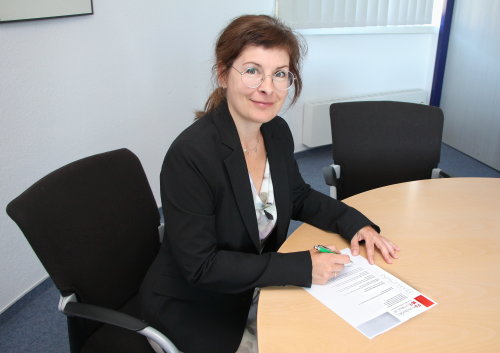 Sylvia Asmussen von der Unterstützung des Ehrenamts des Oberbergischen Kreises unterzeichnet einen Engagementnachweis. (Foto: OBK)