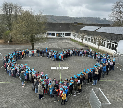 Die Kinder der Schulgemeinde der Gemeinschaftsgrundschule Oberwiehl (GGS) und der Förderschule für Sprache des Oberbergischen Kreises (FÖS) haben auf dem Schulhof ein Herz gebildet: als Zeichen für ein gutes Miteinander. (Foto: OBK)