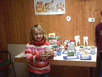 Das Foto zeigt ein Mädchen vor einem Tisch mit einer Produktauswahl von Lebensmitteln.