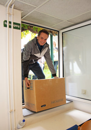 Helfer tragen Kisten mit Kleidung in die Einrichtung. (Foto: OBK)