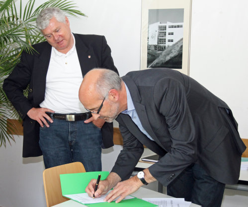 Rektor Jürgen Horn unterzeichnet den Kooperationsvertrag im Beisein von Schuldezernent Dr. Jorg Nürmberger (Foto:OBK). 