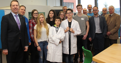 Landrat Jochen Hagt (l.) besuchte gemeinsam mit Sozialdezernent Dr. Jorg Nürmberger (re.) das Schülerlabor, in dem der Chemiekurs der Klasse 9 (Gesamtschule Marienheide) eifrig für die reibungslose Produktion von Kunststoffbechern sorgte. (Foto: OBK)