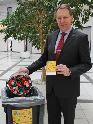 Der Einwurf der ersten Deckel für die Sammeltonne war natürlich Chefsache. Landrat Jochen Hagt lädt alle Bürgerinnen und Bürger ein, sich an der Sammlung zu beteiligen. (Foto: OBK)