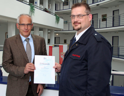 Kreisdezernent Dr. Christian Dickschen (l.) beglückwünscht Andreas Beckmann zum 25-jährigen Dienstjubiläum. (Foto: OBK) 