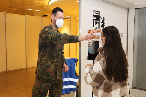 Am Eingang begrüßen die Soldatinnen und Soldaten die Impflinge, fordern zum Hände-Desinfizieren auf und messen die Körpertemperatur der angemeldeten Personen. (Foto: OBK)