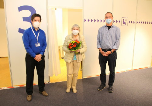 Stephan Hahn (Leiter vom Dienst Kassenärztliche Vereinigung; links) und Uwe Alefelder (Leiter vom Dienst Impfzentrum; rechts) begrüßten Elisabeth Klug. (Foto: OBK)