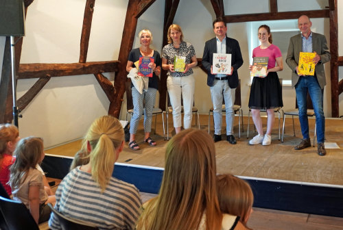Freuten sich über die starke Beteiligung, u.a. der Wiehler Einrichtungen, am Bundesweiten Vorlesetag und überreichten noch einmal symbolisch die Bücherpakete (v.l.): Anke Koester, Leiterin des Amtes für Schule und Bildung des Oberbergischen Kreises; Johanna Holst, Vorstand der Hans Hermann Voss-Stiftung; Ulrich Stücker, Bürgermeister der Stadt Wiehl; Marleen Diederichs, stv. Leiterin des Fachbereich 3 Schule, Kultur, Tourismus & Sport, Stadtverwaltung Wiehl; Norbert Fischer, pädagogischer Mitarbeiter des Bildungsbüro Oberberg. (Foto: OBK) Freuten sich über die starke Beteiligung, u.a. der Wiehler Einrichtungen, am Bundesweiten Vorlesetag und überreichten noch einmal symbolisch die Bücherpakete (v.l.): Anke Koester, Leiterin des Amtes für Schule und Bildung des Oberbergischen Kreises; Johanna Holst, Vorstand der Hans Hermann Voss-Stiftung; Ulrich Stücker, Bürgermeister der Stadt Wiehl; Marleen Diederichs, stv. Leiterin des Fachbereich 3 Schule, Kultur, Tourismus & Sport, Stadtverwaltung Wiehl; Norbert Fischer, pädagogischer Mitarbeiter des Bildungsbüro Oberberg. (Foto: OBK)