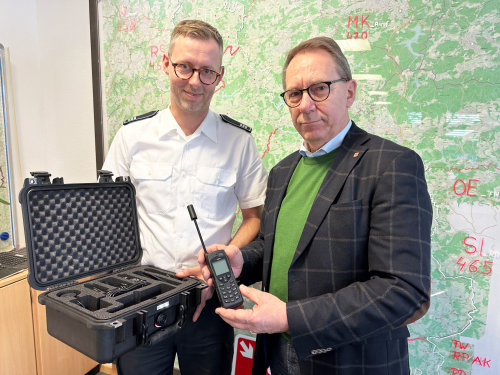Julian Seeger (Leiter Feuer- und Rettungsleitstelle Oberbergischer Kreis, l.) und Landrat Jochen Hagt zeigen ein Satellitentelefon und das dazugehörige Equipment. (Foto: OBK) Julian Seeger (Leiter Feuer- und Rettungsleitstelle Oberbergischer Kreis, l.) und Landrat Jochen Hagt zeigen ein Satellitentelefon und das dazugehörige Equipment. (Foto: OBK)