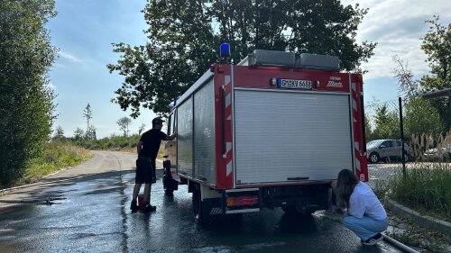 Auszubildende reinigen Feuerwehrautos auf dem Übungsgelände in Wiehl/Brächen. (Foto: OBK)