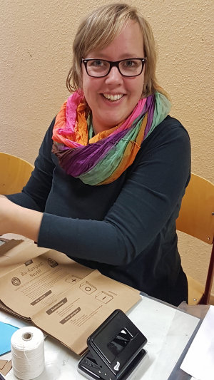 Nicole Meyer half beim Basteln von Sternen und Schneeflocken aus Butterbrottüten. (Foto: OBK)