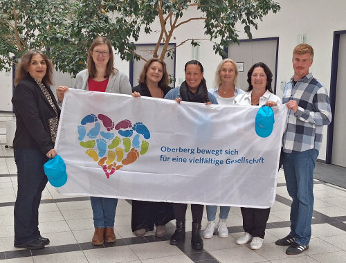 Werben auch in 2026 für Vielfalt und Toleranz im Oberbergischen Kreis - Die Initiative "Oberberg bewegt sich" ruft zum Mitmachen auf (v. l.): Belma Hadzeric, Diakonie - Evangelischer Kirchenkreis an der Agger; Sarah Krämer, Leiterin des KI Oberberg; Ingrid Forsting, Caritasverband für den Oberbergischen Kreis e.V.; Angelina Hoppe, Caritasverband für den Oberbergischer Kreis e.V.; Anja Lepperhoff, Geschäftsführerin des Kreissportbund Oberberg e.V.; Birgit Steuer; Bildungsbüro Oberberg und Bastian Voigt, KI Oberberg. (Foto: OBK)