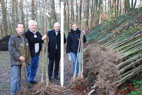 Das Foto zeigt:: Stephan Müller von der Biologische Station (l.), Nicole Fischer vom Landschaftsverband und Werner Mürmann vom Oberbergischen Kreis (v.r.) überreichen Klaus Törell von der Dorfgemeinschaft Hahn die ersten der rund 2000 Pflanzen.