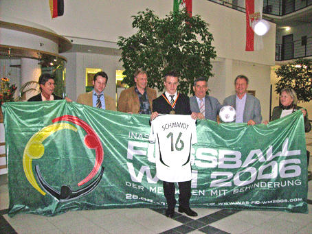 (v.l.) Brigitte Kappenstein, Jürgen Roth, Hugo Krakau, Patrick Schwandt, Landrat Hagen Jobi, Friedhelm-Julius Beucher und Helma Irle mit dem Banner der Fußball-WM 2006 Der Menschen mit Behinderung