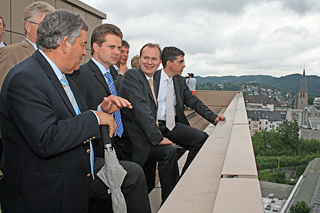 Foto: Landrat Hagen Jobi, Ulrich Stücker (v.l.), Bodo Löttgen (hinten) sowie Bürgermeister Frank Helmenstein (r.) erläuterten Minister Breuer (2.v.r.) die Entwicklung auf dem Steinmüllergelände vom Dach eines Hochhauses aus. (Foto: OBK) 