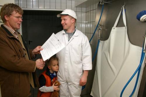 Dr. Stefan Kohler überreicht Metzger Gregor Rosenbaum, der eine neue Hygieneschleuse einbauen musste, die Zulassung zum EU-Schlachtbetrieb. (Foto: OBK)