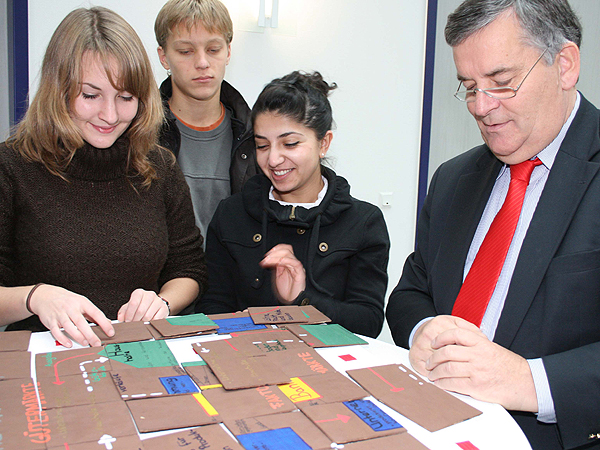 Hat der Landrat den Wirtschaftskreislauf verstanden? Beim Puzzlen beweist er sein Fachwissen. (Foto: OBK)