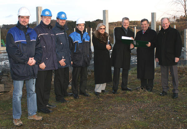 Landrat Hagen Jobi (zweiter von rechts) übergibt im Beisein von Bürgermeister Gregor Rolland (rechts) und der Leiterin der Kreisbaufsicht, Gabriele Keil-Riegert (vierte von rechts), die Baugenehmigung an Michael Pfeiffer, persönlich haftender Gesellschafter der BPW Bergische Achsen KG (Foto: OBK)