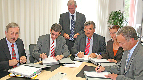 Die Bürgermeister Becker-Blonigen (Wiehl) und Helmenstein (Gummersbach), Geschäftsführer Finklenburg, Landrat Jobi, Landesrätin Hoffmann-Badache und Waldbröls Bürgermeister Koester unterzeichnen die Verträge. (Foto: Oberbergischer Kreis)