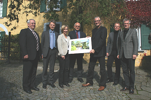 Museumsleiterin Dr. Gudrun Sievers-Flägel präsentiert den Kunst Architekturkalender vor historischer Kulisse (v.l.n.r.: Heinrich Pauli, stellvertr. Bürgermeister Nümbrecht; Carsten Brand, Geschäftsführer Stiftungen der Kreissparkasse Köln; Dr. Gudrun Sievers-Flägel, Museumsdirektorin; Werner Krüger, Kulturdezernent OBK;  Rainer Gaertner, Fotograf; Michael Welp, Firma Welpdruck Wiehl; Bernd Hombach, Vorsitzender des Fördervereins Schloss Homburg. (Foto: OBK) 