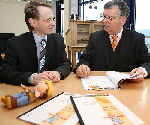 Thomas Wojahn von der Wirtschaftsförderung überreicht Landrat Hagen Jobi (r.) die ersten druckfrischen Exemplare des Investorenleitfadens, der Checklisten und Informationen rund um gewerbliche Bauvorhaben enthält. (Foto: OBK)