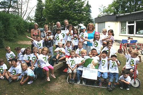 Karin Kohl und Karin Müller vom Jugendamt, Sozialdezernent Dr. Jorg Nürmberger, Bürgermeister Peter Koester und Kindergartenleiterin Ina Hombach (hinten v.l.) freuen sich mit den Kindern über den Sonderpreis. (Foto: OBK)