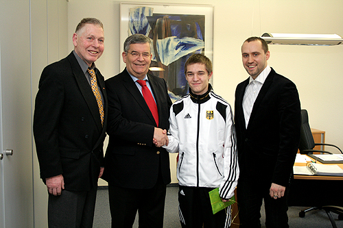Der Betreuer Friedhelm Meisen, Landrat Hagen Jobi und Trainer Nika Tsurtsumia (r) sind stolz auf den Karatekämpfer Dennis Schwetschenko (2.v.r.). (Foto: OBK) 