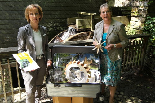 Museumsdirektorin Gudrun Sievers-Flägel (links im Bild) und Museumspädagogin Birgit Ludwig-Weber präsentieren den Museumskoffer an der historischen Mühle von Schloss Homburg (Foto:OBK)  