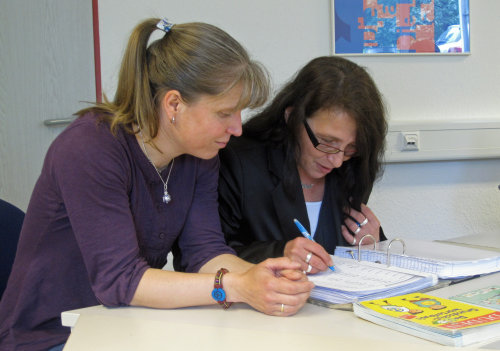 Kursleiterin Sandra Komp und eine Teilnehmerin arbeiten mit Wörterlisten (Foto:OBK) 