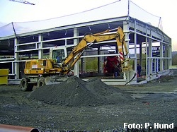 Bagger vor Rohbau einer Fahrzeughalle