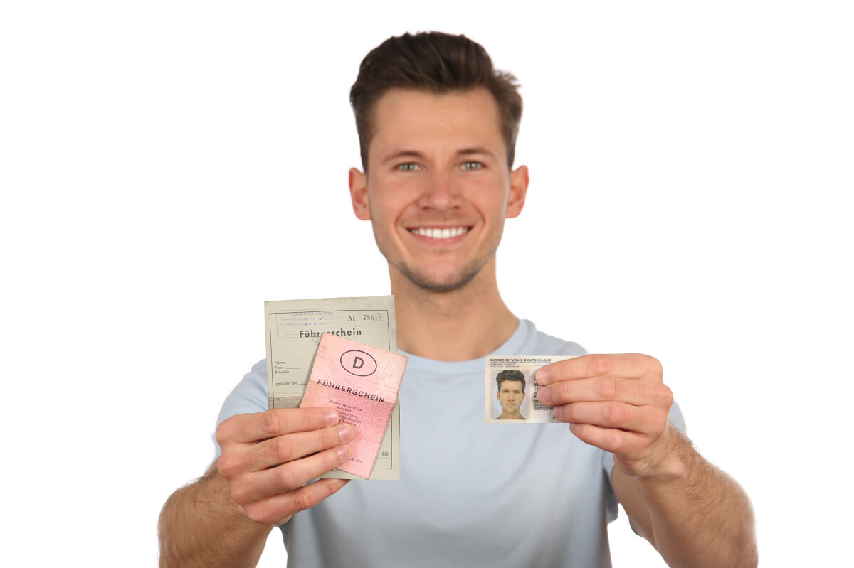 Junger Mann zeigt alte und neue Führerscheine