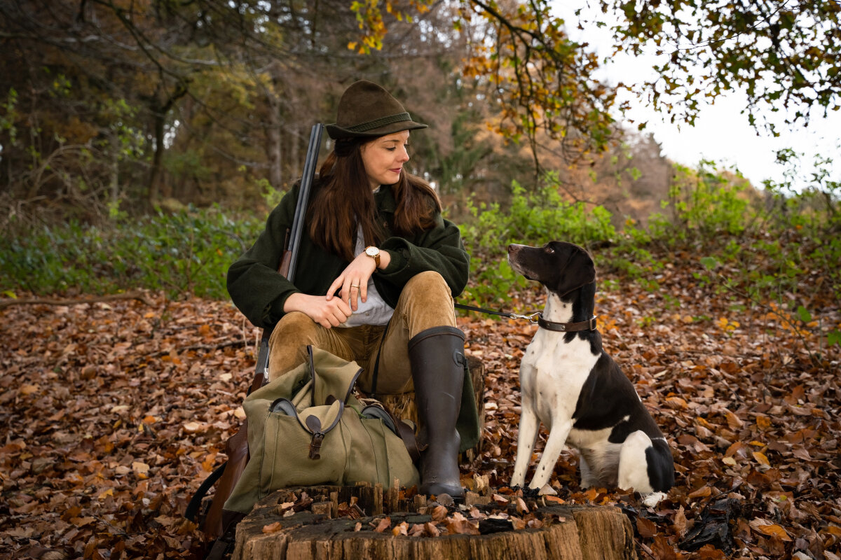 Jagd und Wildhege, junge Jägerin mit ihrem Jagdhund bei einem Reviergang, jagdliches Symbolfoto.