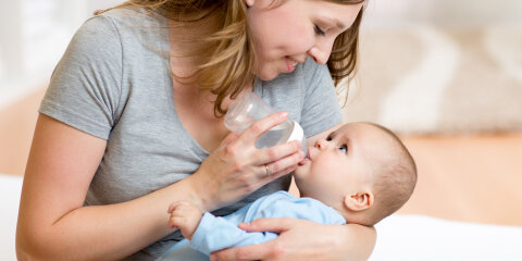 young mother feeding her adorable baby