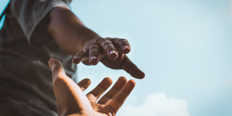 Help Concept hands reaching out to help each other in dark tone.