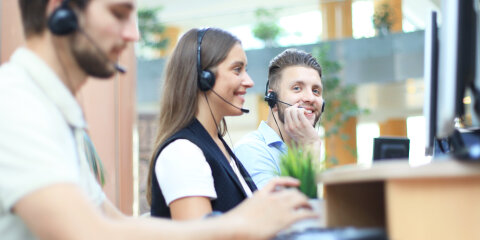Attractive positive young businesspeople and colleagues in a call center office.