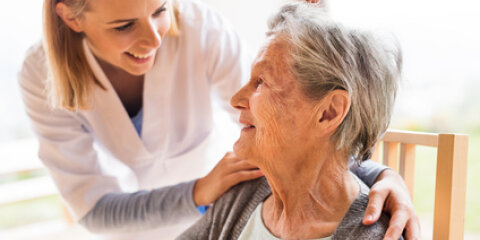 Health visitor and a senior woman during home visit.