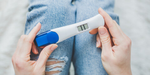 Woman looking on positive pregancy test