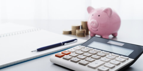 Saving money and household finance management.  Calculator and piggy bank.