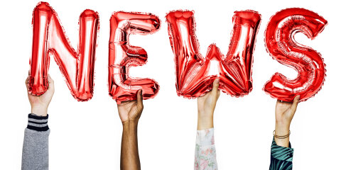 Vier Hände halten rote Folienballons, die die Buchstaben N, E, W und S formen, vor einem weißen Hintergrund.