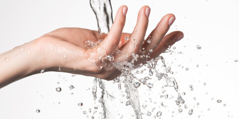 Closeup woman hand under the stream of water