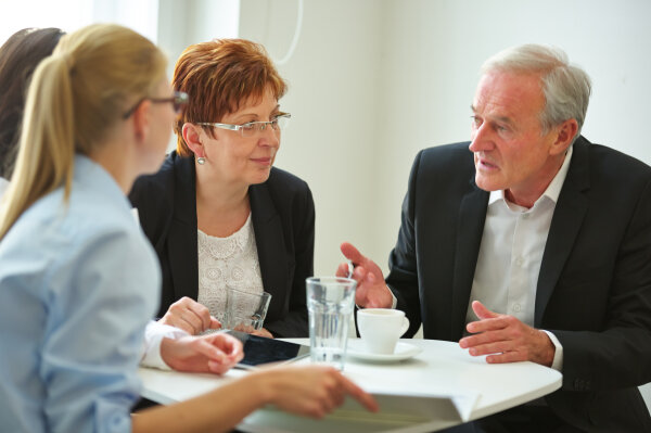 Business Team am Tisch mit Tablet PC