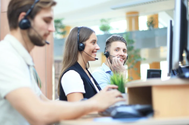 Attractive positive young businesspeople and colleagues in a call center office.