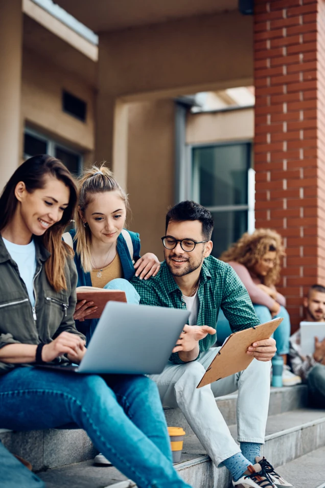 Group of university students e-learning on laptop at campus.