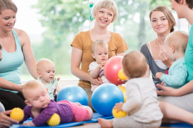 Young women in mother and child group playing with their baby kids