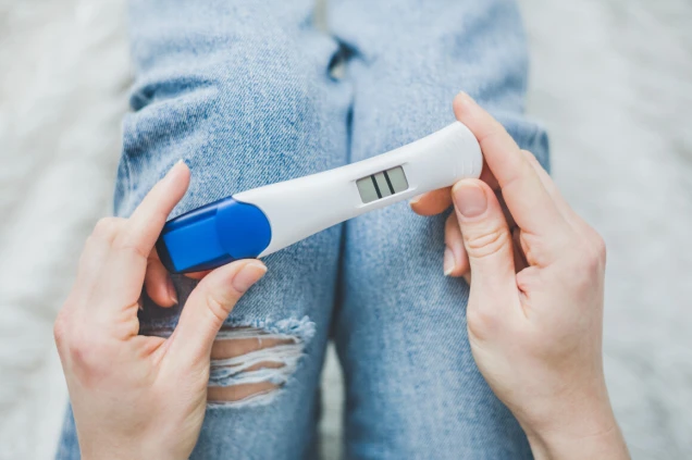 Woman looking on positive pregancy test