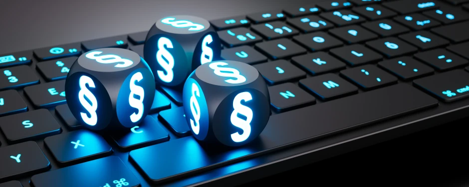 Leuchtende Würfel mit Paragraphen-Symbol auf Tastatur