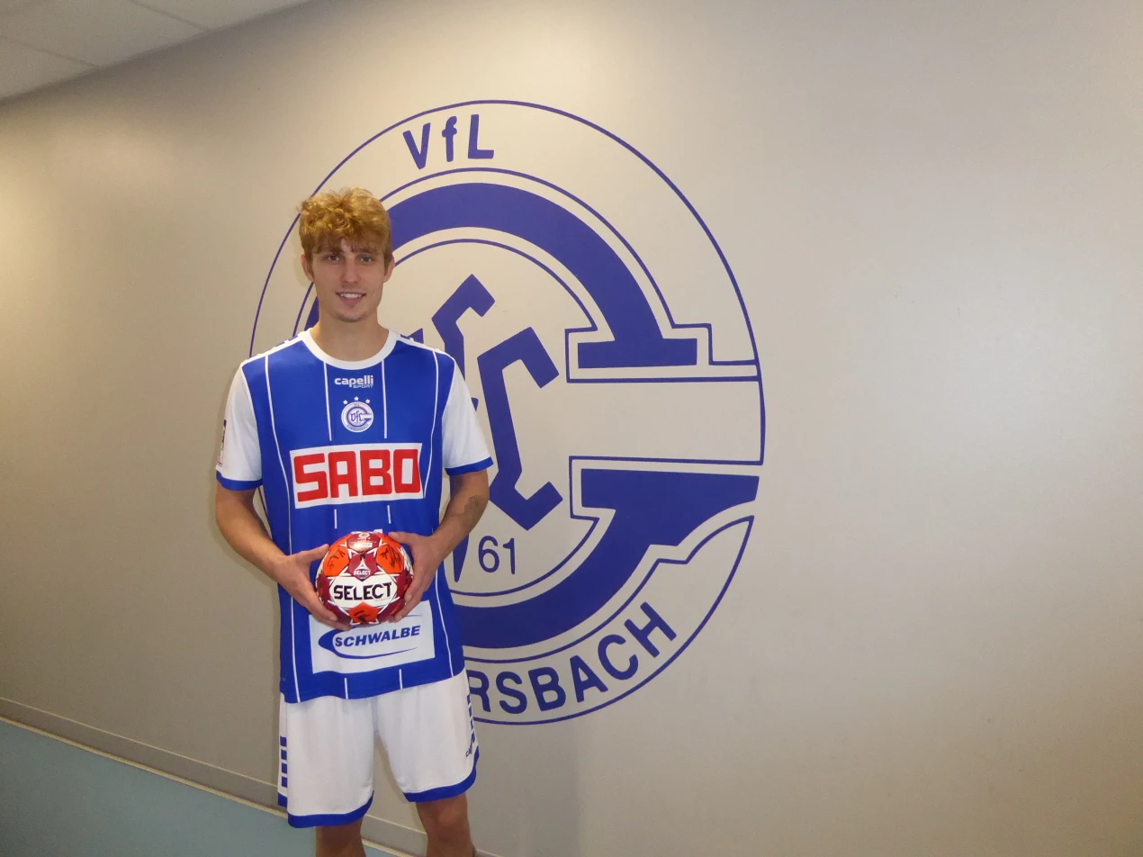 Profispieler Mathis Häseler präsentiert den signierten Handball: Der Handballbundesligist VfL Gummersbach unterstützt die Vorleseaktion des Bildungsbüro Oberberg. (Foto: OBK)