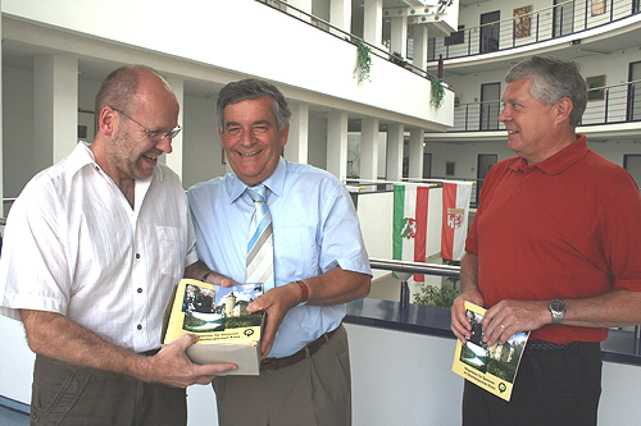 Landrat Hagen Jobi (M.) und Sozialdezernent Dr. Jorg Nürmberger (l.) übergaben einen Karton druckfrischer Exemplare des neuen Seniorenwegweisers an Axel Ganter von der Senioren- und Pflegeberatungsstelle der Stadt Gummersbach. (Foto: OBK)