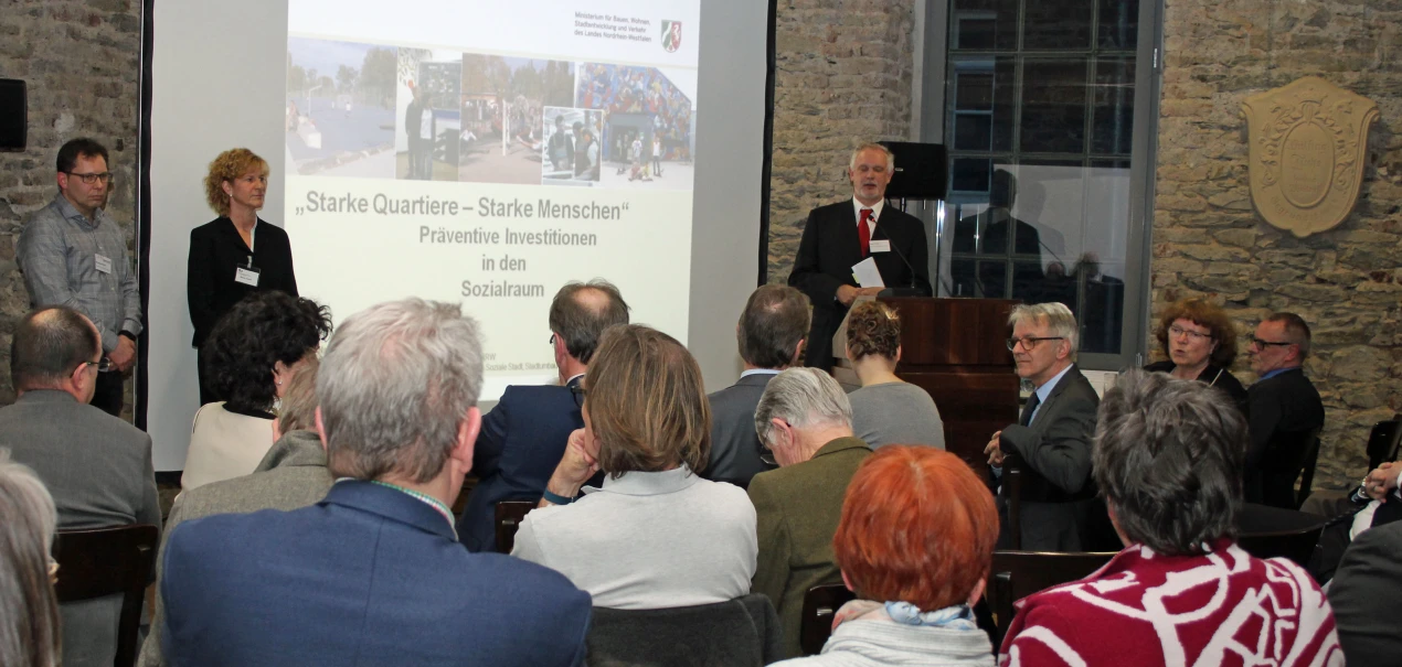 Reger Austausch bei der Auftaktveranstaltung "Starke Quartiere - starke Menschen": (l.) Burkhard Klein, Bauamt der Stadt Rade und Beate Fiedler, Kreis- und Regionalentwicklung OBK stehen als Ansprechpartner für die Quartiersentwicklung der Wupperorte bereit. Uwe Stranz, Dezernent für Kreisentwicklung, moderiert. (Foto OBK)  